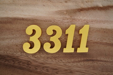 Golden Arabic numerals on a real brown and white wooden floor number 3311