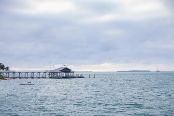 Obraz premium Boathouse and pier, storm clouds background