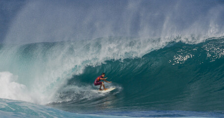 Surfer surfing big tropical wave barrel tube at Banzai Pipeline in Hawaii