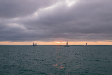 Storm clouds over the ocean with sailboat and Catamaran on horizon