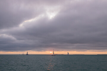 Storm clouds over the ocean with sailboat and Catamaran on horizon
