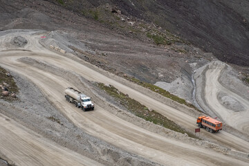 Fuel truck on dangerous gravel mountain road transporting diesel fuel to Kumtor gold mine. Industry freight truck transportation.