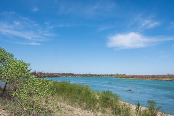 Fototapeta na wymiar Ili river in spring time. Beautiful river with blue water and sky. Wild nature landscape background.