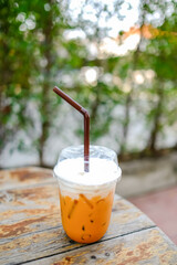 Iced Thai milk tea on a wooden table.