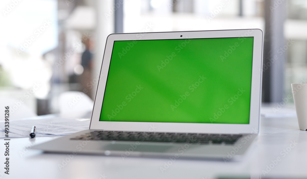 Poster Make sure your landing page makes the loudest statement. Shot of a laptop with a green screen on a desk in a modern office.