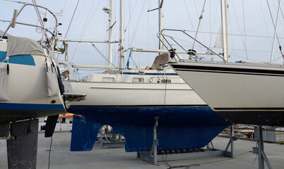 Sailboats standing on land in a yacht club. Service, repair, winterization, transportation, sport,...