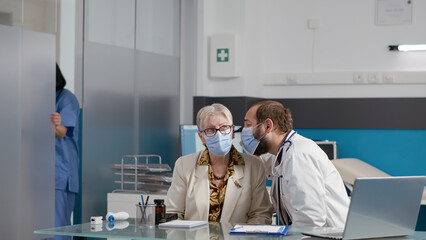 Male doctor using otoscope to do ear examination with retired person, finding treatment to cure...