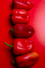 Sweet red pepper lies on a red background.