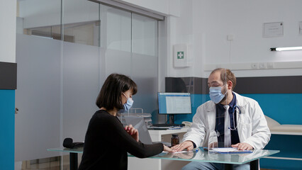 Naklejka premium General practitioner signing checkup papers to give prescription treatment to female patient at medical examination appointment. Physician helping woman, giving medicine cure in cabinet.