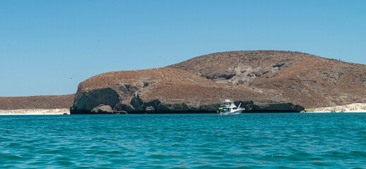 Nautical vessel sayiling on the Sea of cortes in Baja California Sur. Mexico. with mountains and clouds in the background and a beautiful sunny summer morning with blue sky © Victor