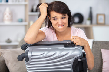 troubled woman has forgotten the code for her suitcase lock