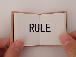 開いた本、ノートにルールの単語