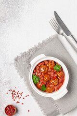 Meat or vegetable meatballs in tomato sauce with beans. Top view.