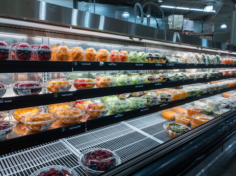Lynnwood, WA USA - circa March 2022: Angled view of plastic bowl containers filled with fruit for sale inside a Town and Country grocery store.