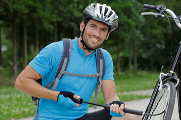 biker pausing to pump bike wheel