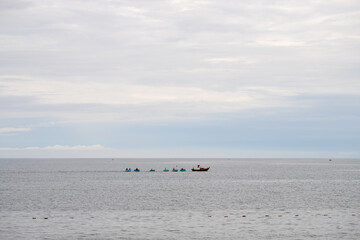A number of Vietnamese traditional fishing boats upon the sea linked to each other.