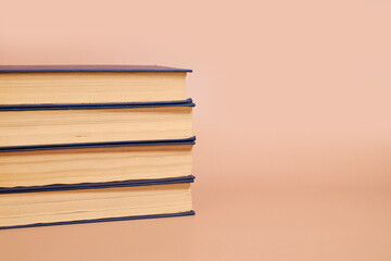 A stack of books on a colored background. Copy space