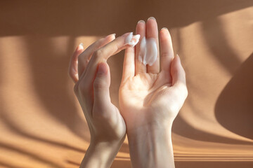 Beautiful women's palms apply cream, lotion to skin. Fingers rub white oily liquid into hands....