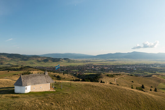 Beautiful Transylvanian landscape. Mountains, Szekler flag, the city of Gheorgheni in the background.