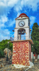 Fototapeta na wymiar The clock and bell tower of the church of Agios Nikolaos in Skiathos Town, Greece