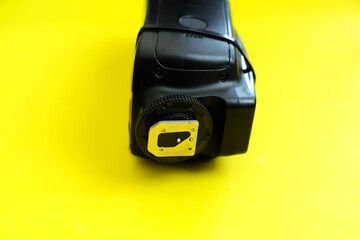 Camera external light tied with clamp on yellow background