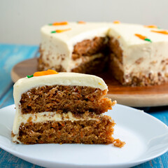 HOME-MADE CARROT CAKE. WITH NUTS AM CARAMEL. BLUE BACKGROUND SLICE