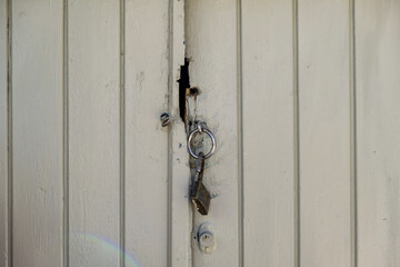 Padlock open, grey wooden door closed. Traditional door detail, close up front view l