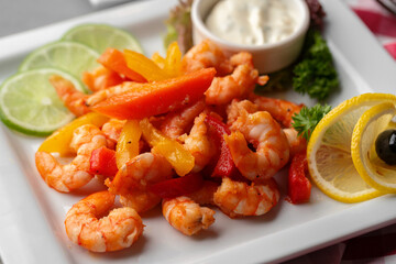 Spicy garlic chilli shrimps in white plate on gray background