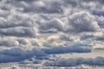 Background. Sky with white cumulus horizontal clouds and gray thunderstorms. which are located below the white clouds. Details
