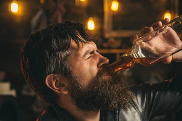 Fotobehang Upset man drinker alcoholic with glass drinking whiskey alone, sad depressed addicted. Alcohol addiction, drunk man. © Volodymyr