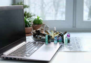 Gemstones crystals, Buddha, laptop on table, blurred window background. Sacred Work Space. Protect from negative energy, uplifting positive spirit, prosperity, harmony, calming, productive the mind