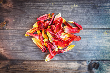 A bunch of tulip petals on a wooden surface, floral background.