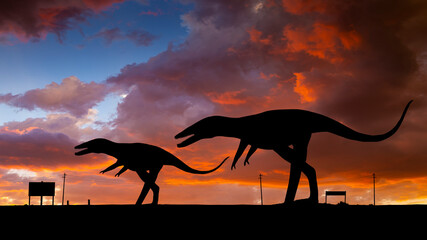 Two Dinosaurs in Silhouette at Sunset along the road near Holbrook Arizona on Route 66
