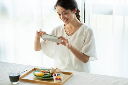 朝食をスマホで撮影をする女性