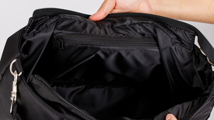 Closeup shot of hands opening showing inside zipper compartments of black large baby toddler kid...