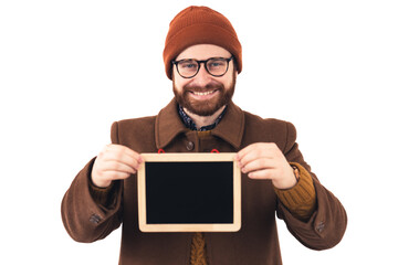 Portrait of a young attractive smiling Caucasian man holding small blackboard brown casual attire isolated studio shot white background . High quality photo