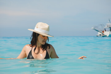 woman in white hat and black swimsuit in blue sea water