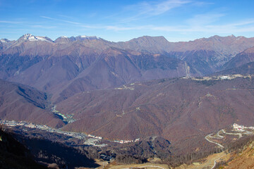 Landscapes in the mountains near Sochi in Russia. High mountain peaks and valleys in the rays of the sun in autumn.