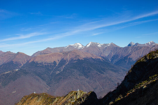 Landscapes in the mountains near Sochi in Russia. High mountain peaks and valleys in the rays of the sun in autumn.