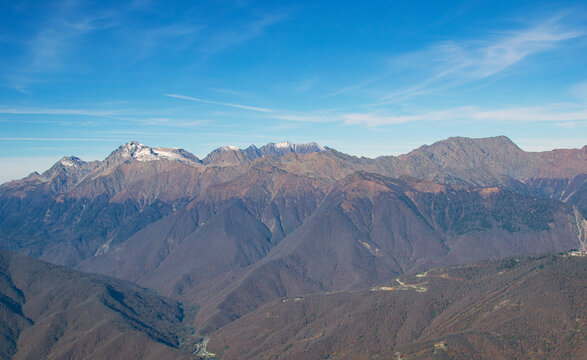 Landscapes in the mountains near Sochi in Russia. High mountain peaks and valleys in the rays of the sun in autumn.