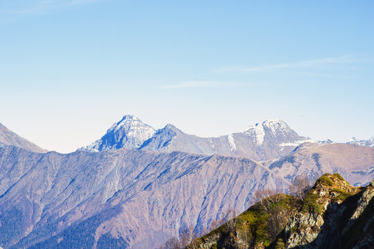 Landscapes in the mountains near Sochi in Russia. High mountain peaks and valleys in the rays of the sun in autumn.