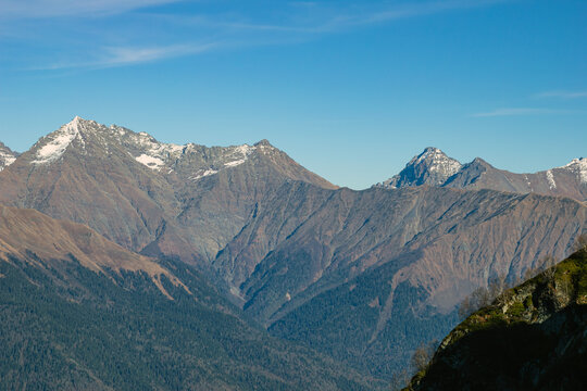 Landscapes in the mountains near Sochi in Russia. High mountain peaks and valleys in the rays of the sun in autumn.