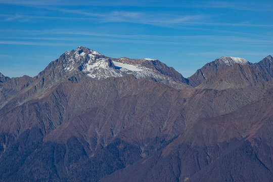 Landscapes in the mountains near Sochi in Russia. High mountain peaks and valleys in the rays of the sun in autumn.