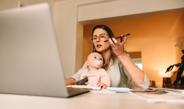 New Mom Taking A Phone Call In Her Home Office