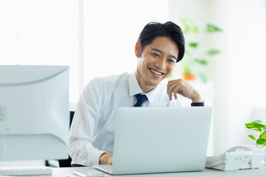 ビジネスオフィスでパソコンに向き合う男性