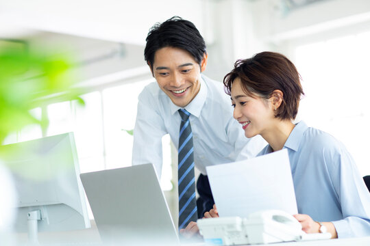 パソコンを一緒に見る男女