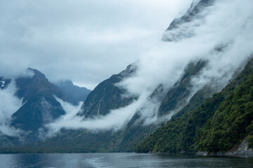 Fototapeta na wymiar Clouds drifting over the mountains at Milford Sound, New Zealand