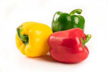 Red Yellow and Green bell peppers on white background.