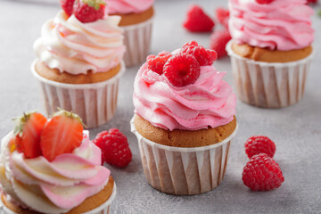 Pink cupcakes with cream and fresh berries