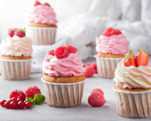 Pink cupcakes with cream and fresh berries
